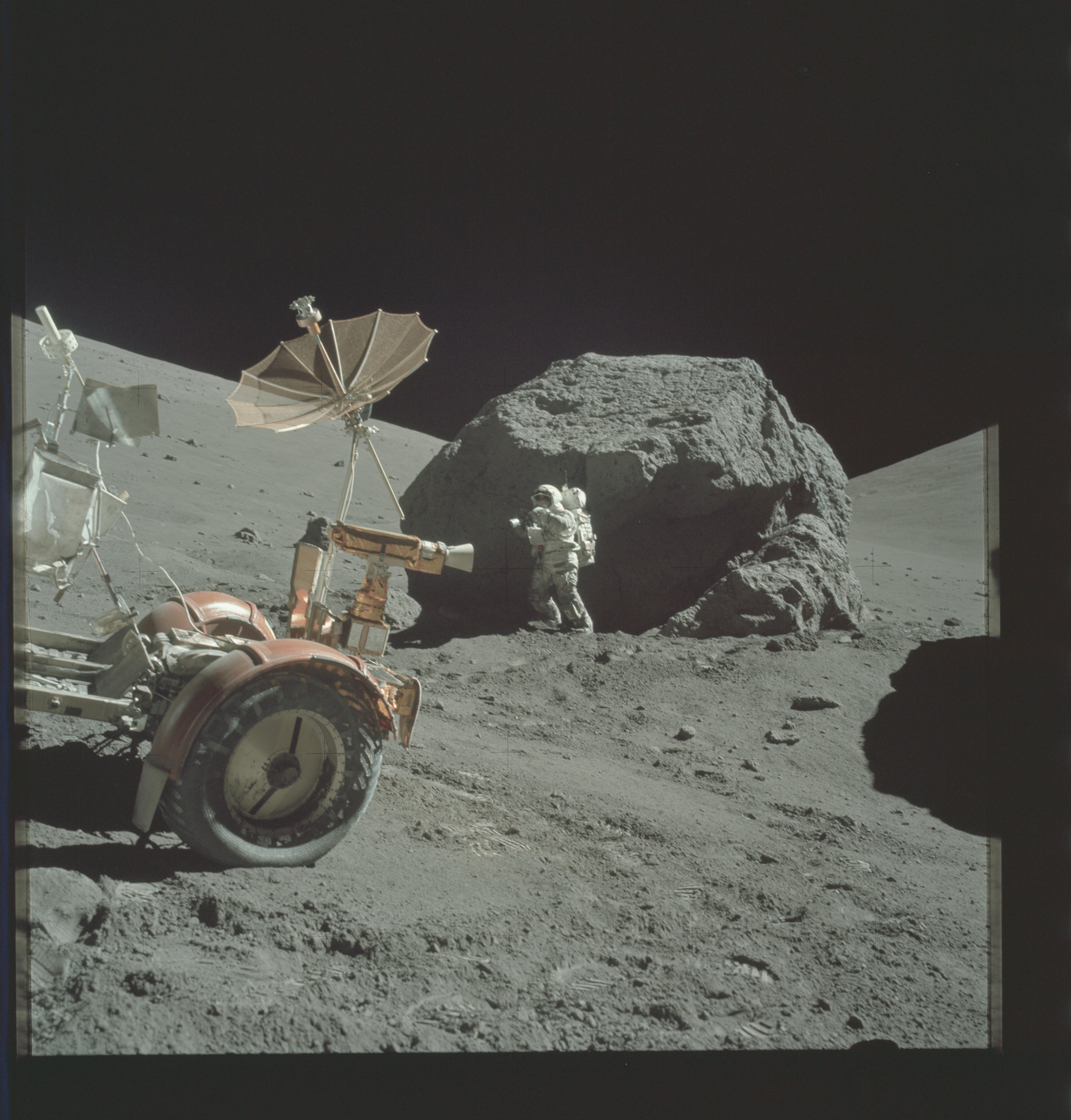 Apollo 17 astronaut Harrison Schmitt beside a large split boulder, photographed by Eugene Cernan